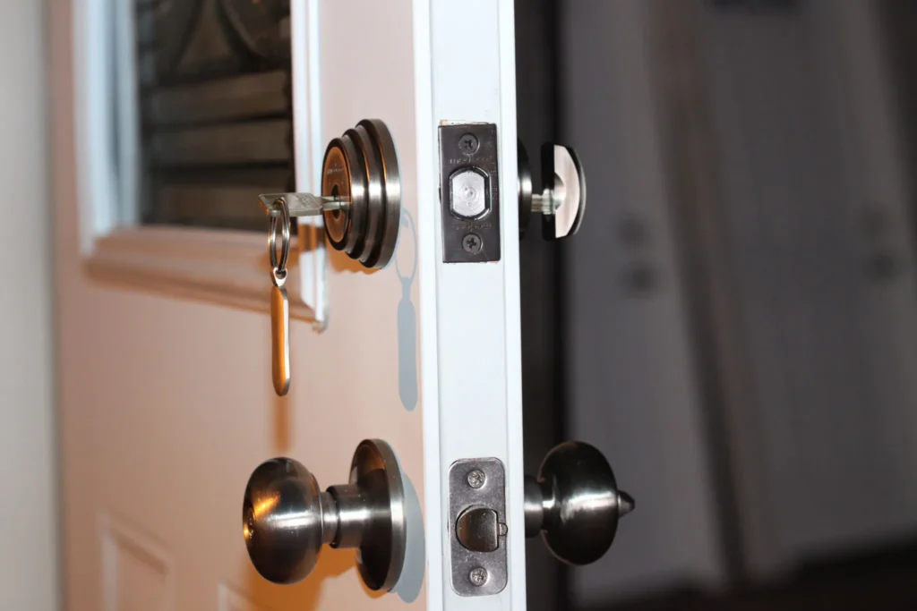 Locksmith inspecting a malfunctioning front door lock